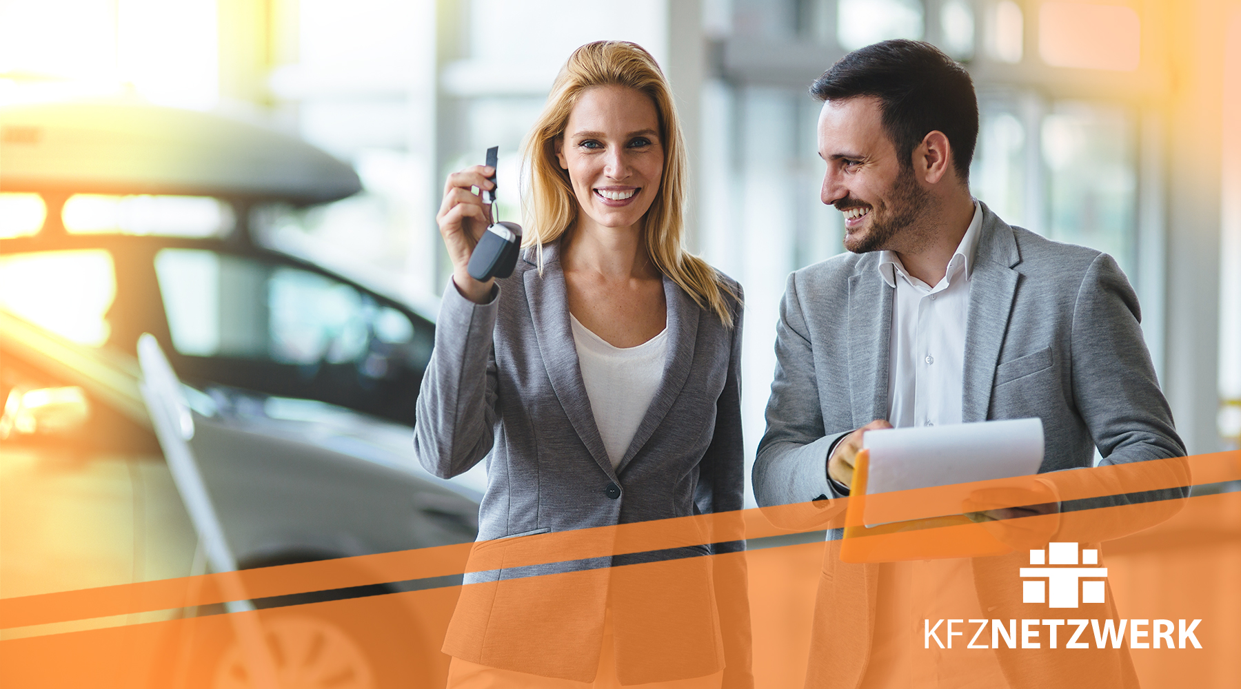 Kfz-Serviceberater übergibt Autoschlüssel un Kundin in einer Autogalerie. Zu Sehen ist auch auf dem Bild das Logo von KFZ-NETZWERK