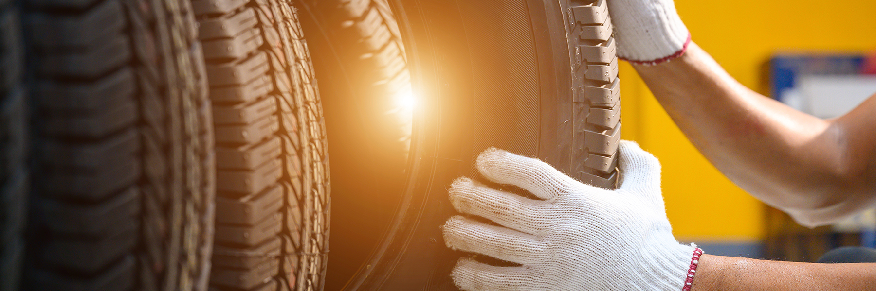 Reifenmonteur prüft den Zustand der neuen Reifen auf Lager, damit sie in einem Servicecenter oder einer Autowerkstatt ausgetauscht werden können
