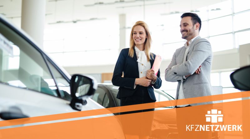 Filialleiterin im Autohaus mit einem Kunden und das Logo von KFZ Netzwerk ist zu sehen